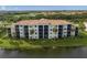A scenic lakefront condo building with beautiful landscaping and serene water views from its balconies at 7015 River Hammock Dr # 204, Bradenton, FL 34212