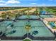 Aerial view of tennis courts with lush landscaping and nearby residential buildings in a beautiful community setting at 7015 River Hammock Dr # 204, Bradenton, FL 34212