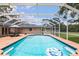 Relax in this screened-in pool with views of the backyard and comfortable seating area at 7401 S Gator Creek Blvd, Sarasota, FL 34241