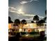 Night view of a well-lit, two-story building with a small garden and palm trees at 749 Manatee Ave, Holmes Beach, FL 34217