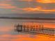 Scenic waterfront view with vibrant sunset, calm water, and peaceful dock at 749 Manatee Ave, Holmes Beach, FL 34217