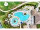 Birds eye view of resort-style pool with sun loungers, tables, palm trees and a pathway to clubhouse at 8004 River Preserve Dr, Bradenton, FL 34212