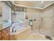 Well-appointed bathroom featuring a tub, walk-in shower, and neutral tiling at 8004 River Preserve Dr, Bradenton, FL 34212