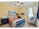 Cozy bedroom with a colorful quilt, ceiling fan, and plenty of natural light at 8004 River Preserve Dr, Bradenton, FL 34212