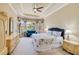 Bright main bedroom with tray ceiling, bay windows, and walk-in closet at 8004 River Preserve Dr, Bradenton, FL 34212