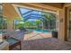 Screened-in pool area with comfortable seating and views of a manicured lawn at 8004 River Preserve Dr, Bradenton, FL 34212