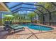 A luxurious screened-in pool and spa with comfortable lounge chairs offer a relaxing outdoor retreat at 8004 River Preserve Dr, Bradenton, FL 34212