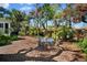 Spacious backyard features a glass-topped table with seating, surrounded by mature trees and lush landscaping at 813 Hudson Ave, Sarasota, FL 34236