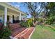 Brick patio with a beautiful manicured backyard surrounded by mature trees and shrubbery at 813 Hudson Ave, Sarasota, FL 34236