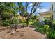 Lush backyard featuring mature trees, tropical plants, and an outdoor dining area, perfect for entertaining at 813 Hudson Ave, Sarasota, FL 34236