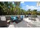 Spacious outdoor balcony with wicker furniture and lush tropical views under a blue sky at 813 Hudson Ave, Sarasota, FL 34236