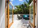 Outdoor balcony showcasing comfortable wicker seating and lush tropical backyard views at 813 Hudson Ave, Sarasota, FL 34236