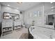 Bright bathroom featuring a soaking tub, double vanity, and bright windows with plantation shutters at 813 Hudson Ave, Sarasota, FL 34236