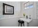 Charming powder room with pedestal sink, black fixtures, and decorative wallpaper near a bright window at 813 Hudson Ave, Sarasota, FL 34236