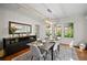 Bright dining room with wood floors, white wainscoting, designer light fixture and a view to the backyard at 813 Hudson Ave, Sarasota, FL 34236