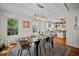 Dining room with wainscoting, hardwood floors, a modern chandelier, and a view to the kitchen at 813 Hudson Ave, Sarasota, FL 34236