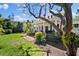 Charming home exterior with a wide porch, lush lawn, and mature trees, perfect for outdoor living at 813 Hudson Ave, Sarasota, FL 34236