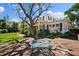 Charming two-story home with mature landscaping, a covered porch, and an inviting outdoor seating area at 813 Hudson Ave, Sarasota, FL 34236