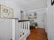 Upstairs hallway with white wood paneling, hardwood floors, and a built-in bookcase at 813 Hudson Ave, Sarasota, FL 34236