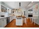 Spacious kitchen featuring white cabinetry, butcher block island, and open shelving for storage at 813 Hudson Ave, Sarasota, FL 34236