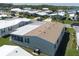 A bird's-eye view of a cozy home boasting a blend of tan and white roofing amidst green landscapes at 8424 Regal Way, Palmetto, FL 34221