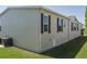 Exterior view showing light siding, well-maintained lawn, and mature landscaping around the home at 8424 Regal Way, Palmetto, FL 34221