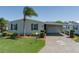 Charming single-story home featuring a carport, well-maintained lawn, and decorative palm tree driveway inlay at 8424 Regal Way, Palmetto, FL 34221