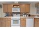 Well-equipped kitchen with wood cabinetry, tile backsplash, and modern white appliances at 8424 Regal Way, Palmetto, FL 34221