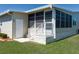 Screened porch with white railing, a door to the backyard, and steps to the yard at 8424 Regal Way, Palmetto, FL 34221
