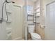 Functional bathroom featuring a shower, toilet, and convenient shelving for storage at 8798 Herbison Ave, North Port, FL 34287
