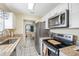 Modern kitchen featuring stainless steel appliances, granite counters, and bright white cabinets at 8798 Herbison Ave, North Port, FL 34287
