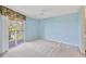 Bright bedroom with light blue walls, ceiling fan, neutral carpet, and balcony access for scenic views at 9620 Club South Cir # 5306, Sarasota, FL 34238