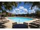 Enjoy the expansive community pool with comfortable lounge seating, tables, and a building in the background at 9620 Club South Cir # 5306, Sarasota, FL 34238