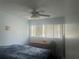 Bedroom with blue walls, ceiling fan, and large window with blinds at 965 Whitman Dr, Sarasota, FL 34243