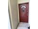 A close up exterior view of a red painted front door with a window insert and a blue water bottle hanging on the door handle at 5691 Bentgrass Dr # 15-102, Sarasota, FL 34235