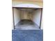 View of the empty garage with a door to the interior, a fire extinguisher, and an automatic door at 5691 Bentgrass Dr # 15-102, Sarasota, FL 34235