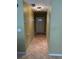 A tiled hallway that leads to the front door with warm wall paint and a ceiling light fixture at 5691 Bentgrass Dr # 15-102, Sarasota, FL 34235
