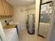 Laundry room with washer, dryer, water heater, and storage cabinets at 5691 Bentgrass Dr # 15-102, Sarasota, FL 34235