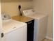 This laundry room features a washer, dryer, and utility counter for folding and storage at 5691 Bentgrass Dr # 15-102, Sarasota, FL 34235