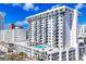 Stylish white condo building boasting a rooftop pool with comfortable lounge area and blue skies at 101 S Gulfstream Ave. # 9C, Sarasota, FL 34236