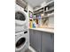 Laundry room featuring front loading washer/dryer, gray cabinets and ample storage at 101 S Gulfstream Ave. # 9C, Sarasota, FL 34236