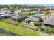Aerial view of backyard with patio, neighboring homes, lush green lawns, and a tranquil pond at 11037 77Th E St, Parrish, FL 34219
