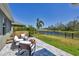 Backyard patio with fire pit and comfortable chairs, overlooking a lush lawn and serene water view at 11037 77Th E St, Parrish, FL 34219
