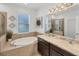 Bright bathroom featuring a soaking tub, double vanity with granite countertops, and a glass-enclosed shower at 11037 77Th E St, Parrish, FL 34219