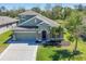 Beautiful home with a well-manicured lawn, palm trees, and a two-car garage at 11037 77Th E St, Parrish, FL 34219