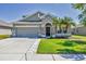 Charming single-Gathering home with a two-car garage, well-manicured lawn, and lush palm trees at 11037 77Th E St, Parrish, FL 34219