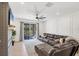 Spacious living room with a large leather sectional, modern ceiling fan, and sliding doors to the patio at 11037 77Th E St, Parrish, FL 34219