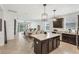 Open-concept kitchen and living area features an island, dining table, and a seamless flow to the outdoor patio at 11037 77Th E St, Parrish, FL 34219