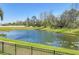 Scenic view of the pond surrounded by lush greenery and a black fence at 11037 77Th E St, Parrish, FL 34219