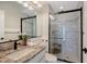 This updated bathroom offers a granite vanity, modern fixtures, and a tiled walk-in shower with glass door at 1110 93Rd Nw St, Bradenton, FL 34209